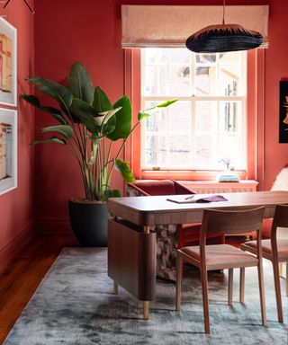 Home office with all red walls and wooden desk