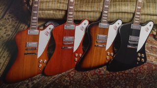 A photo showing a group of Gibson Firebird Platypus guitars leaning against a sofa.