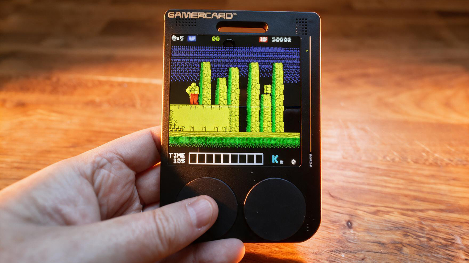 A small black gaming handheld in a wooden table