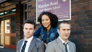 Waterloo Road 'originals' Andrew Treneman Kim Campbell and Jack Rimmer standing by Waterloo Road school sign