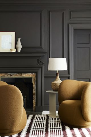 dark grey living room with ochre chairs by Little Greene