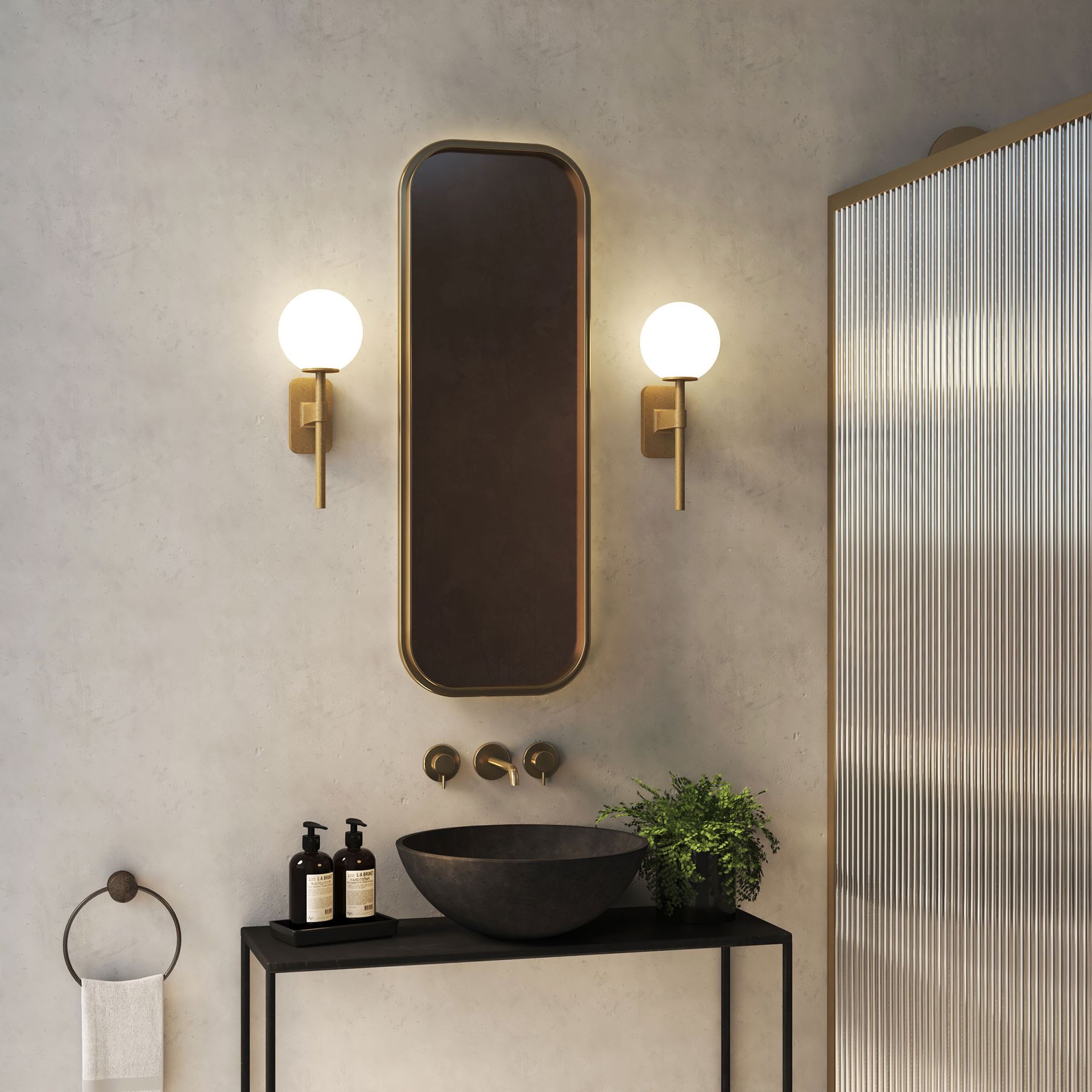 Wall lights on the wall of the bathroom with a brass mirror hung between them