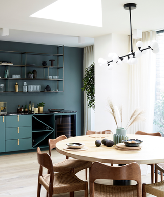 A kitchen with blue cabinets and a dining table