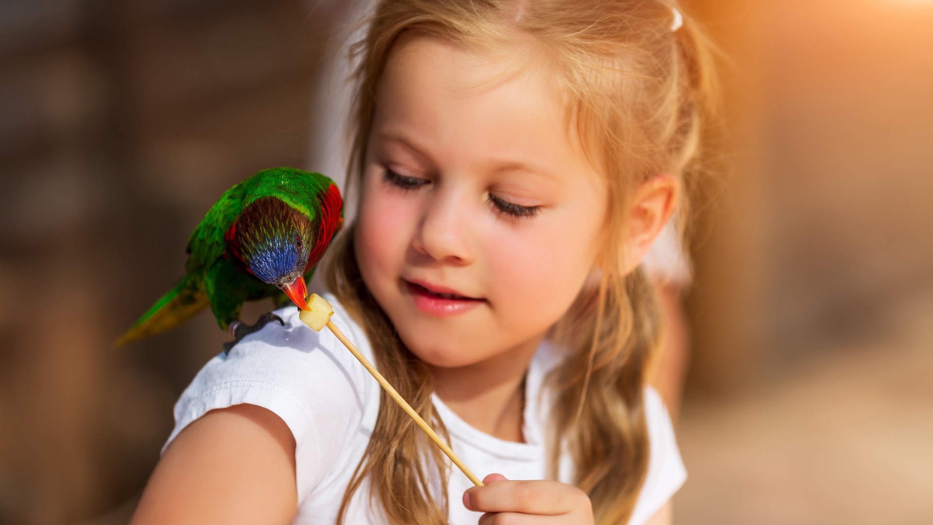Girl with pet parrot on shoulder