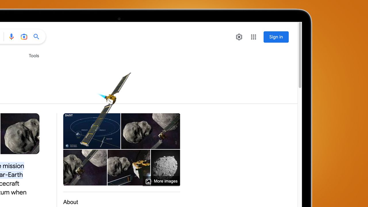 A laptop screen on an orange background showing a Google easter egg for the NASA Dart mission