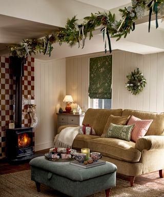 cottage living room with a log burner and christmas decor with a garland strung with bows