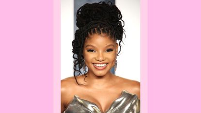 Halle Bailey smiles and wears a gold/silver dress as she attends the 2023 Vanity Fair Oscar Party hosted by Radhika Jones at Wallis Annenberg Center for the Performing Arts on March 12, 2023 in Beverly Hills, California./ in a pink template