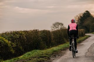 Cyclist rides away from the camera on a winter day