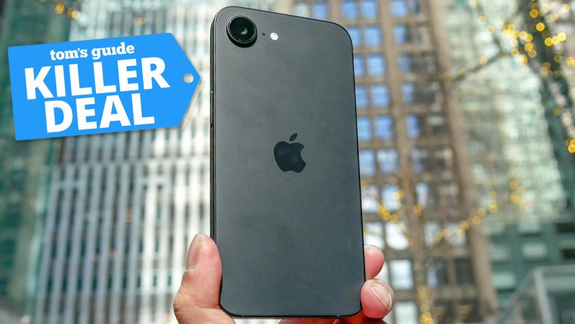 iPhone 16e held in the hand with killer deal badge nearby.