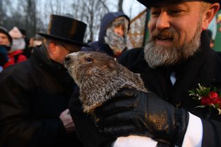 Groundhog handler AJ Derume holds Punxsutawney Phil, who saw his shadow, predicting a late spring during the 136th annual Groundhog Day festivities on February 2, 2022 in Punxsutawney, Pennsylvania.