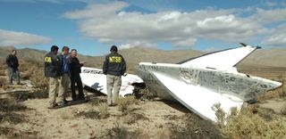 National Transportation Safety Board inspectors stand near debris from the tail section of Virgin Galactic's SpaceShipTwo, which crashed during a test flight on Oct. 31, 2014.