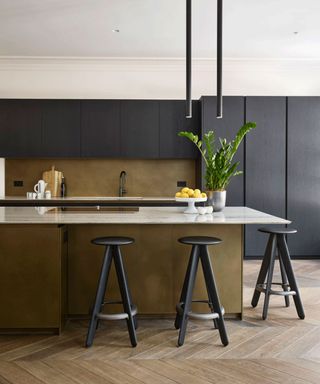 Metallic kitchen island paired with green paint and matte black finishes