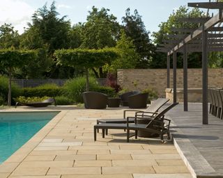 swimming pool with patio, pergola and loungers