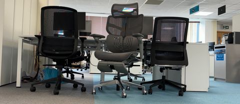 The Hinomi X1 chair, sat in between two black office chairs. 