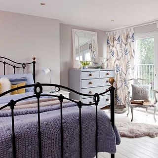 bedroom with wooden flooring and double bed with drawer