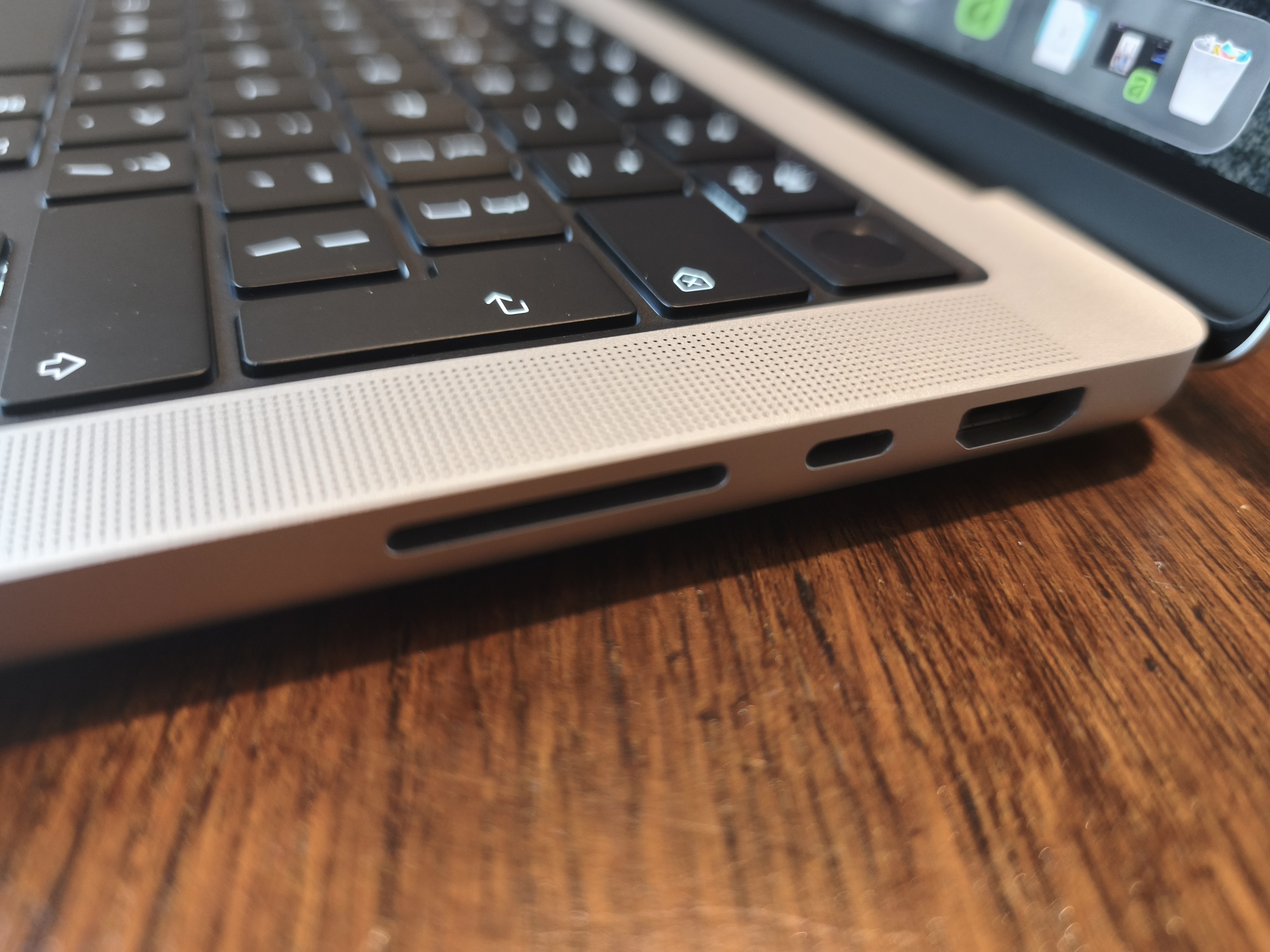 MacBook Pro M5 Max on a dining room table with Apple accessories the Magic Keyboard and Magic Mouse