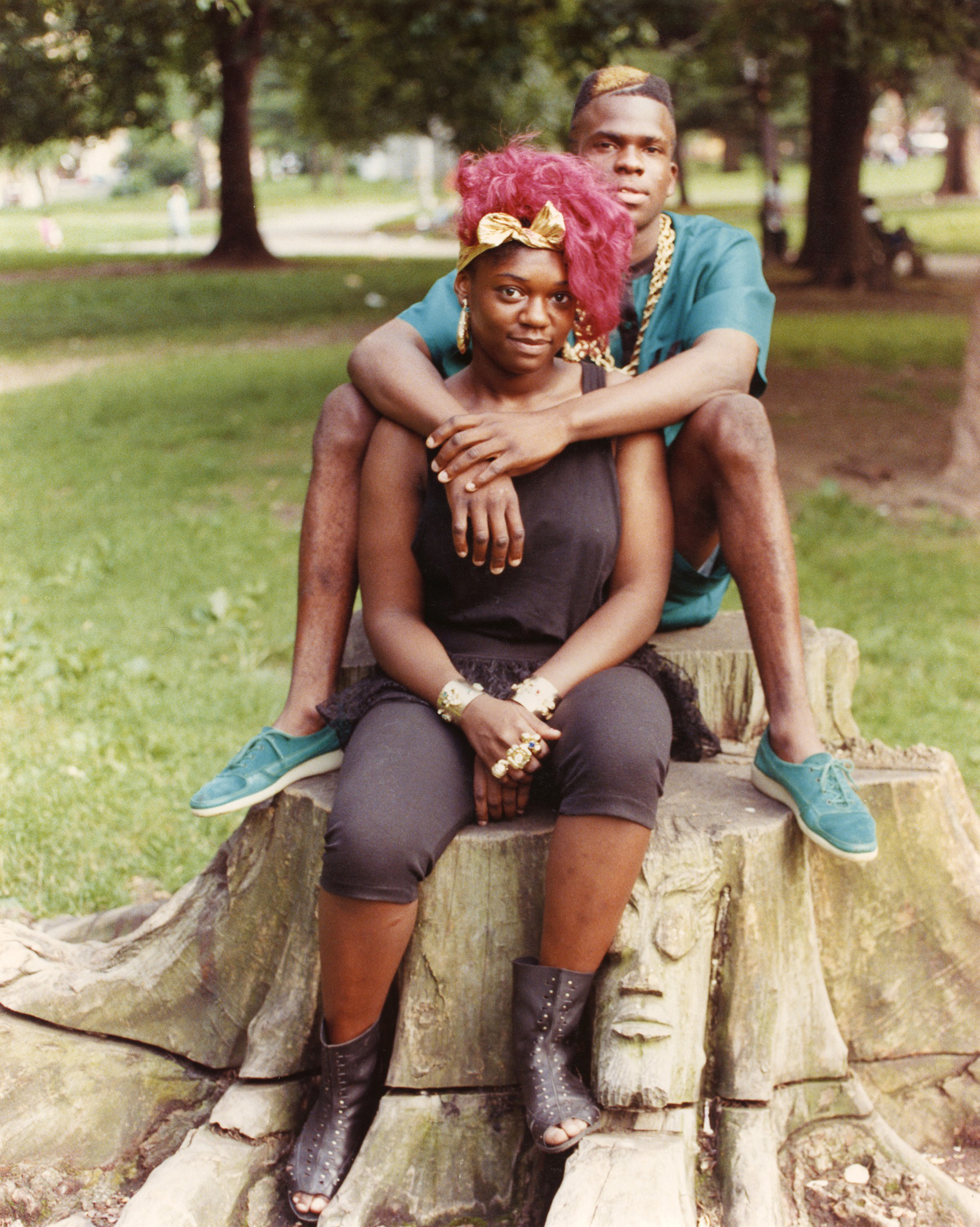 Young man and woman sitting on tree stump