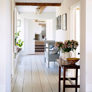 hallway with white floorboards and white flower vase