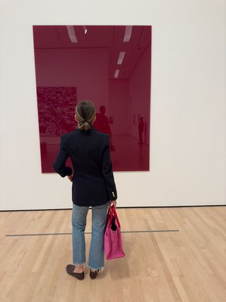 Woman wearing a black blazer and jeans with a pink Parker Thatch handbag.