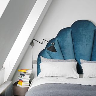 White bedroom with teal velvet scalloped headboard