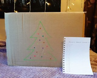 a cardboard box with a Christmas tree drawn on it to collect decluttered items over the festive period