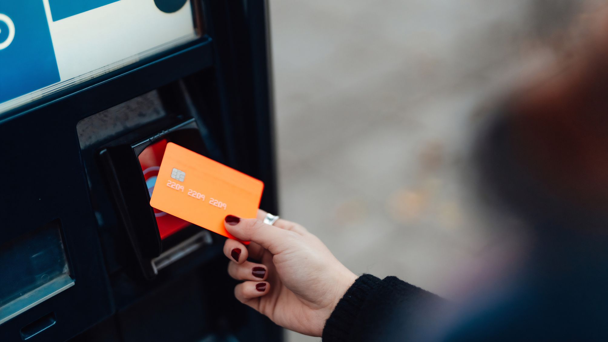 A woman using her credit card to take a cash advance from an ATM.
