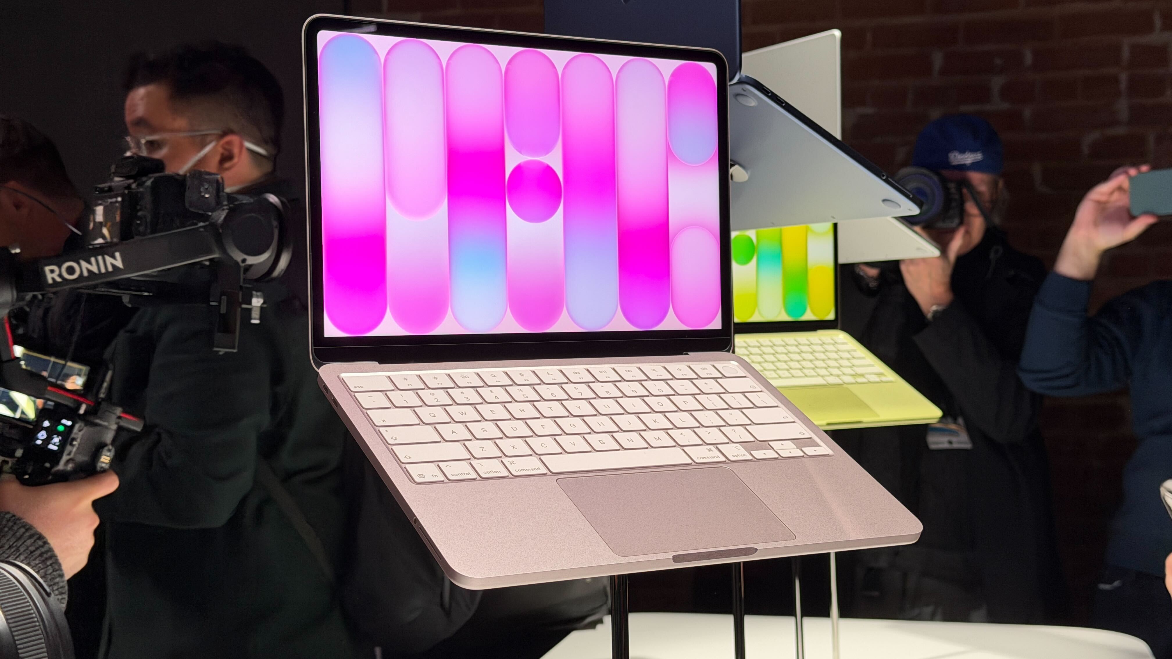 جهاز Apple MacBook Neo باللونين الوردي والأصفر في إحدى الفعاليات