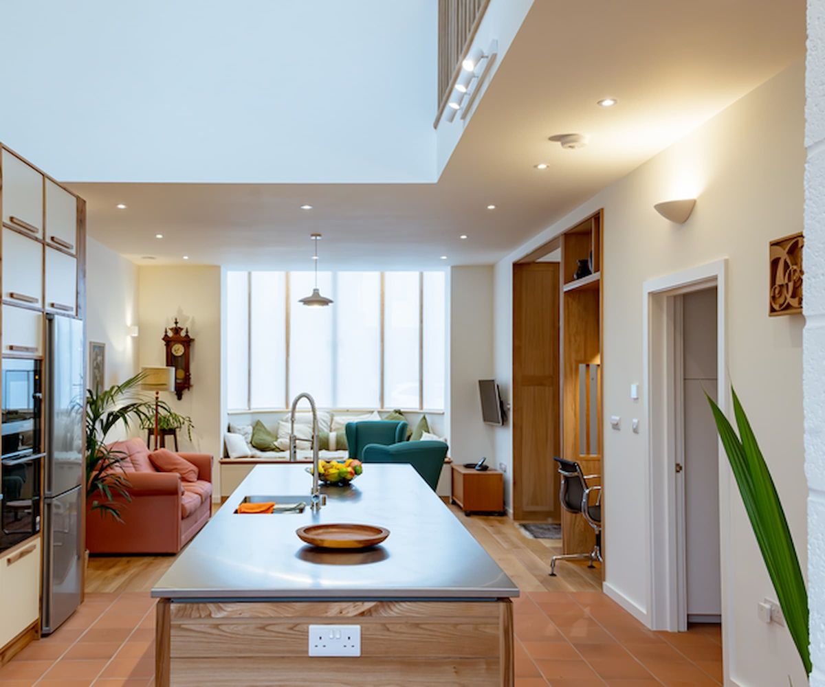 An open plan kitchen with kitchen island with steel cover