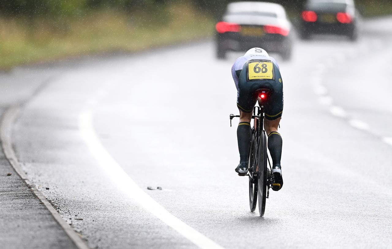 A time triallist races in a time trial on a wet dual carriageway in the UK