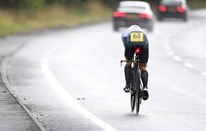 A time triallist races in a time trial on a wet dual carriageway in the UK