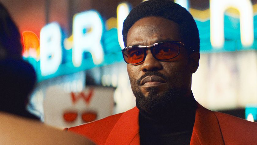 Simon Williams wearing sunglasses and an orange jacket in Wonder Man