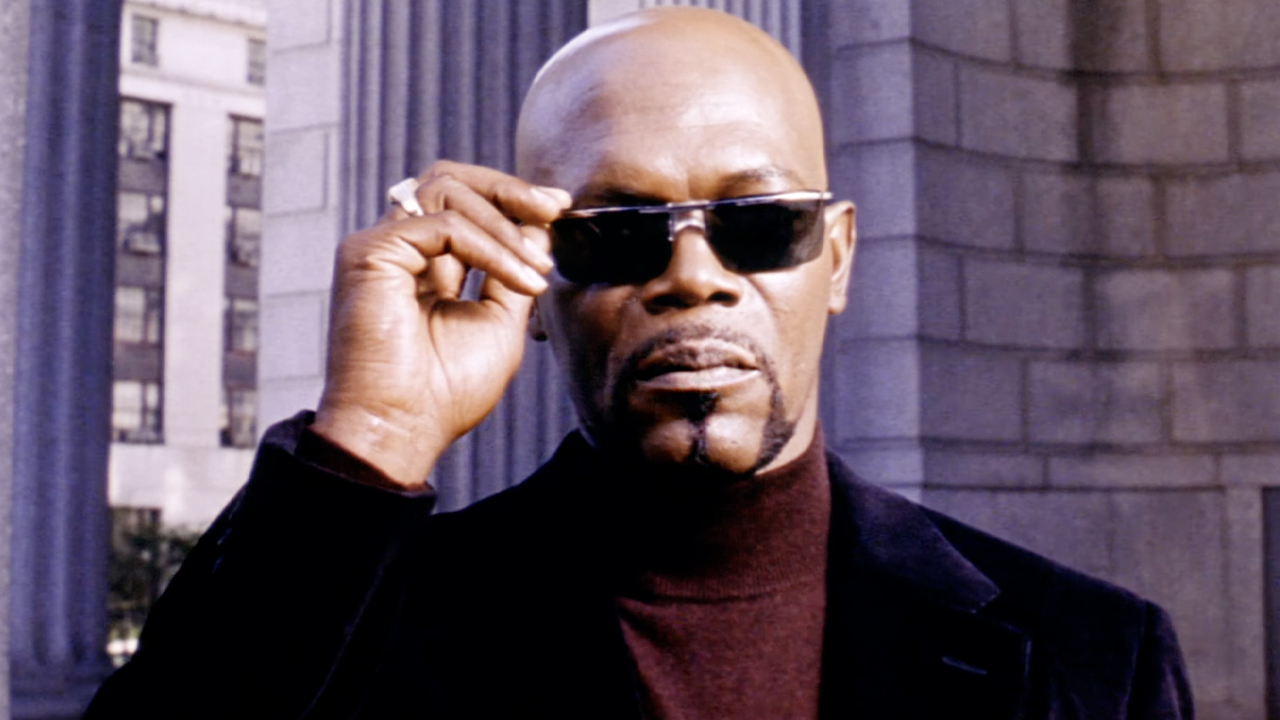 Sam Jackson, as Shaft in the 2000 remake, sports a stylish black jacket, violet turtleneck, and sunglasses. 