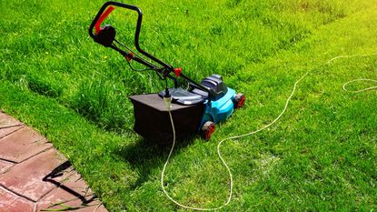 Corded mower vs cordless mower: A corded lawnmower on a lawn