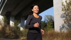 Woman running confidently outside after doing Pilates for runners