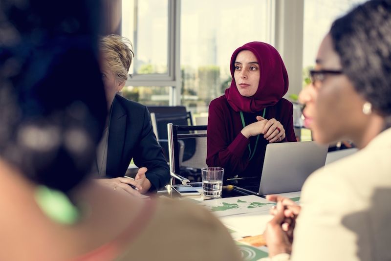 A woman sits at a business meeting.