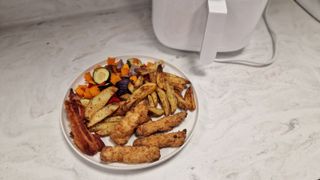 Xiaomi Mi Smart Air Fryer with a complete plate full of bacon, fries, and vegetables
