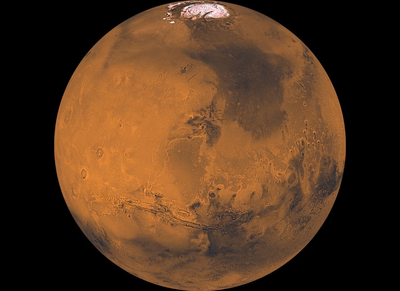 A satellite image of Mars, showing red dust and a white ice cap on top