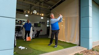 A golfer strikes a golf ball at the range