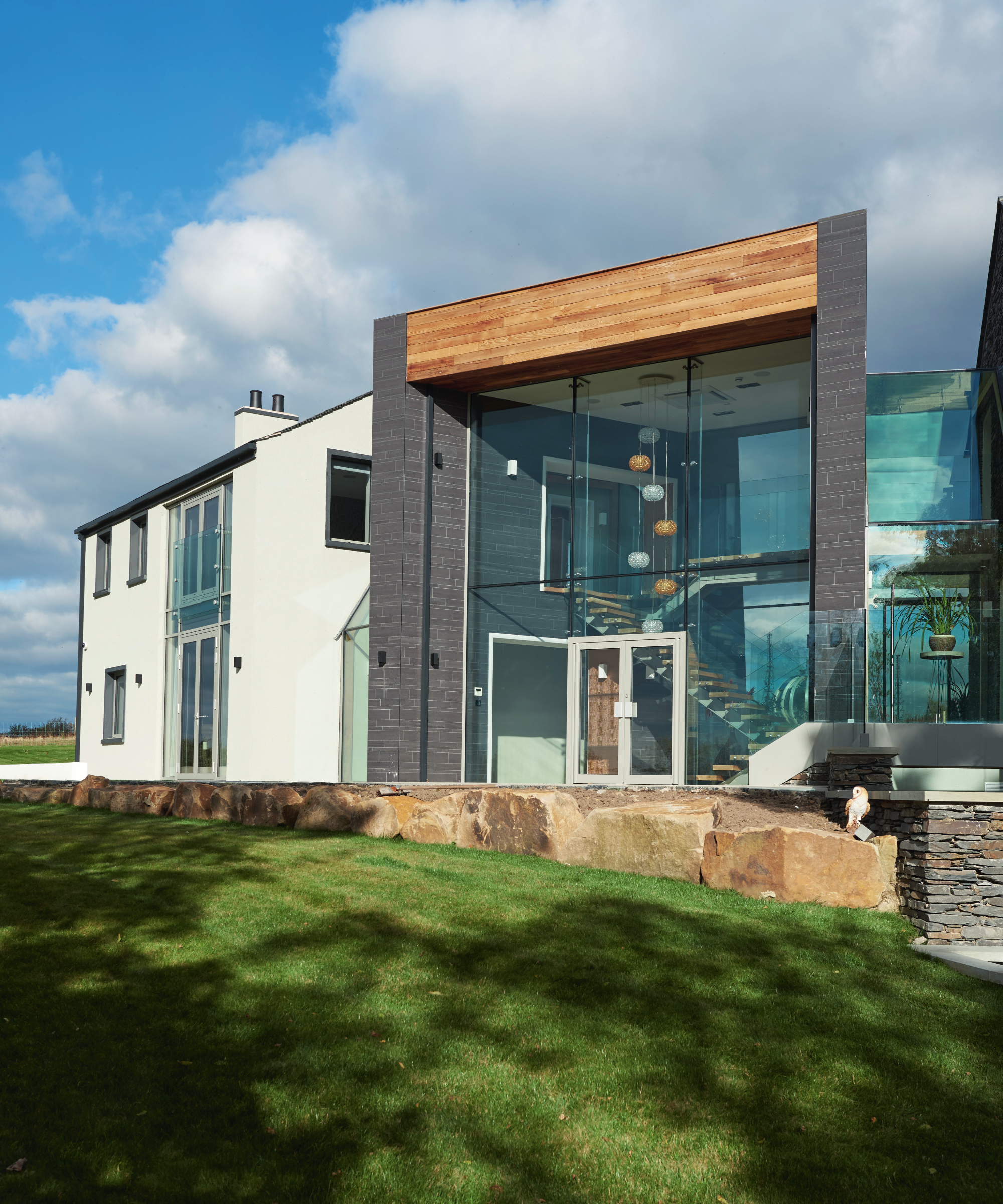 contemporary self build house with glass, timber, render and slate cladding