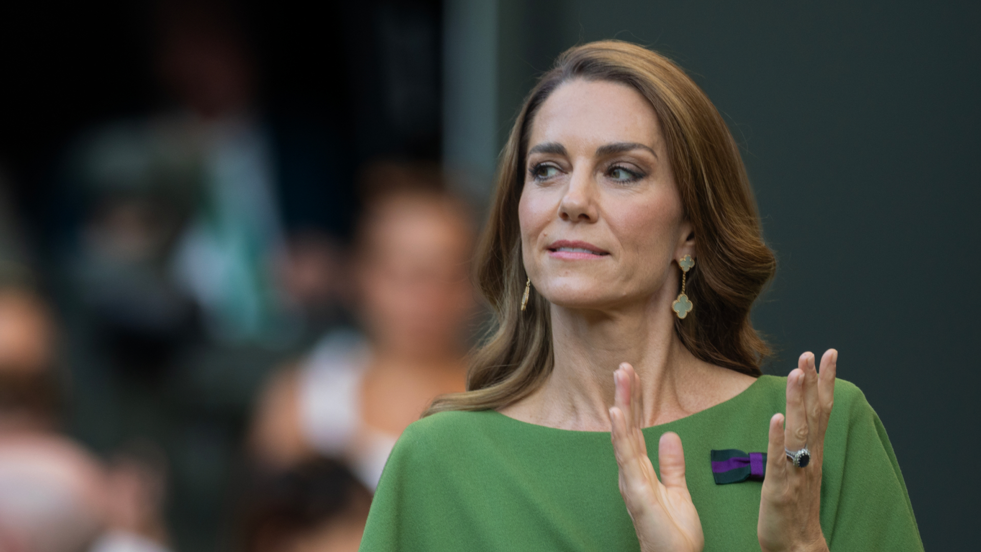 Princess Kate wears a green dress and has long brown hair with blonde highlights while applauding at Wimbledon 2026
