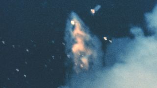 a telephoto image of a rocket breaking apart in-flight.