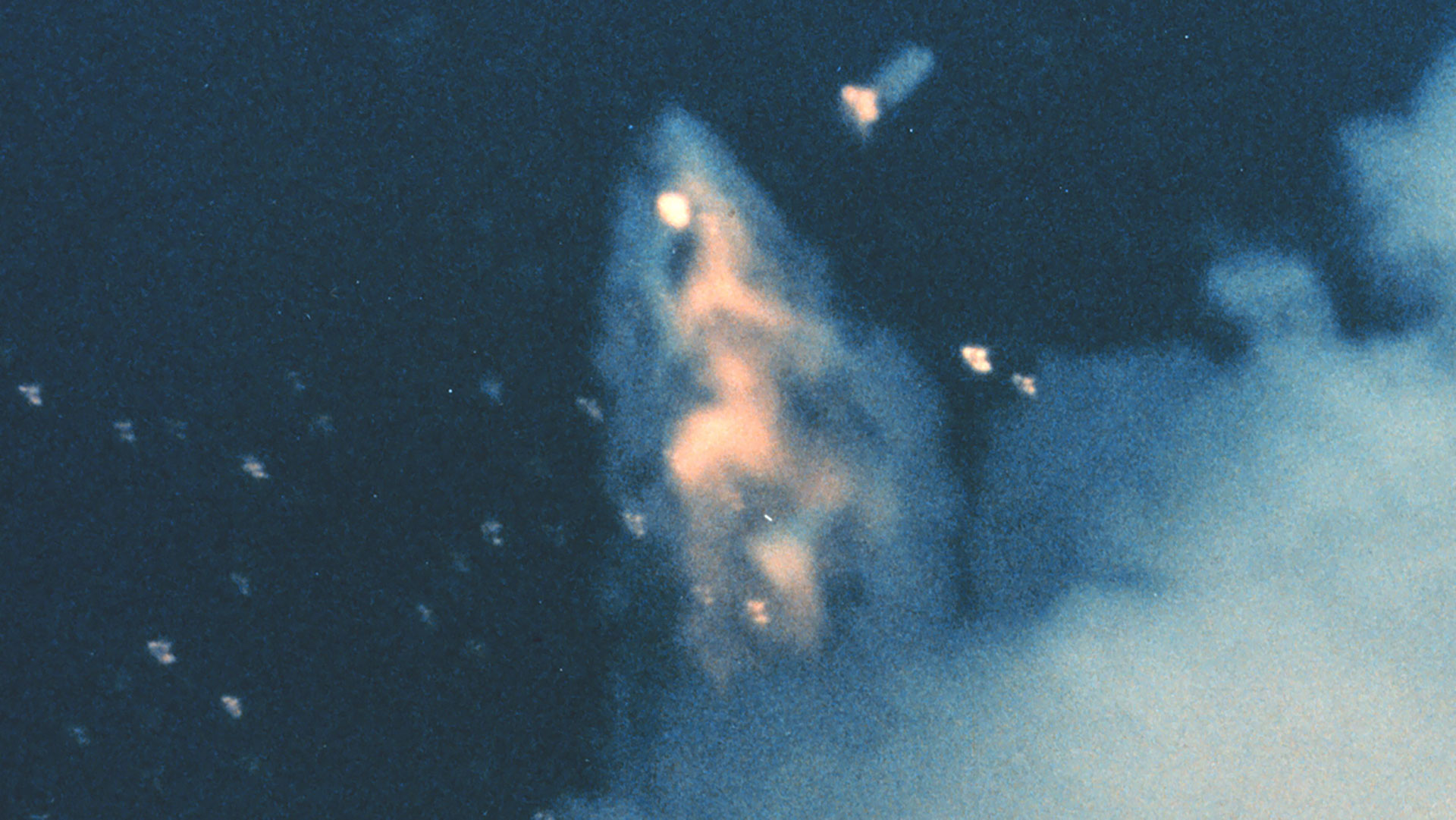 a telephoto image of a rocket breaking apart in-flight.