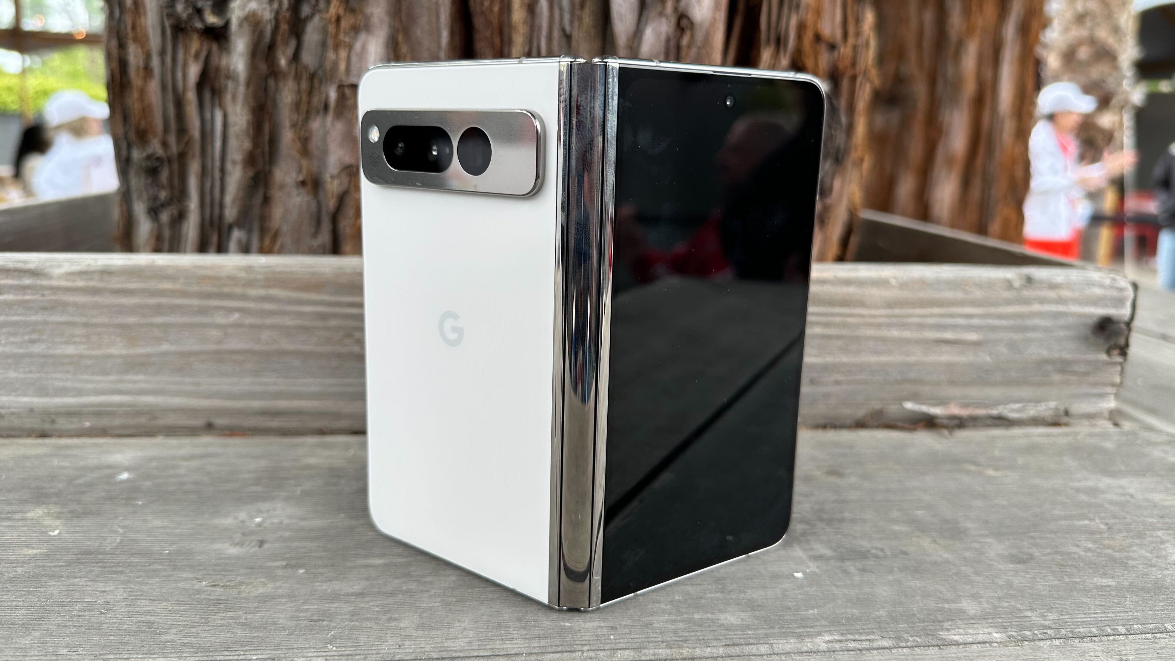 Google Pixel Fold in the Porcelain colorway outdoors.