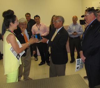 Sarah Hovsepian, manager of the SpaceShop fabrication lab at NASA's Ames Research Center, gives NASA chief Charles Bolden a ceremonial cubesat during his tour of Ames on May 24, 2013. To the left of Bolden is Congressman Mike Honda (D-Calif.); to the right is Ames director Pete Worden.