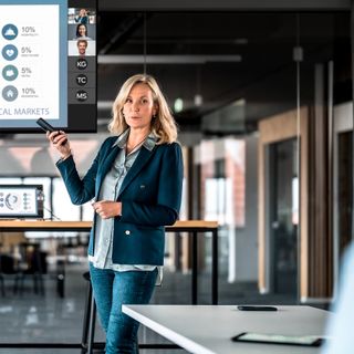 A woman using Crestron content sharing tools in a meeting room.