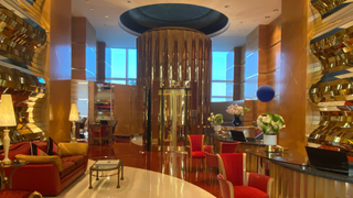 Internal shot of Jumeirah Burj al Arab showing glitzy gold walls and red velvet chairs