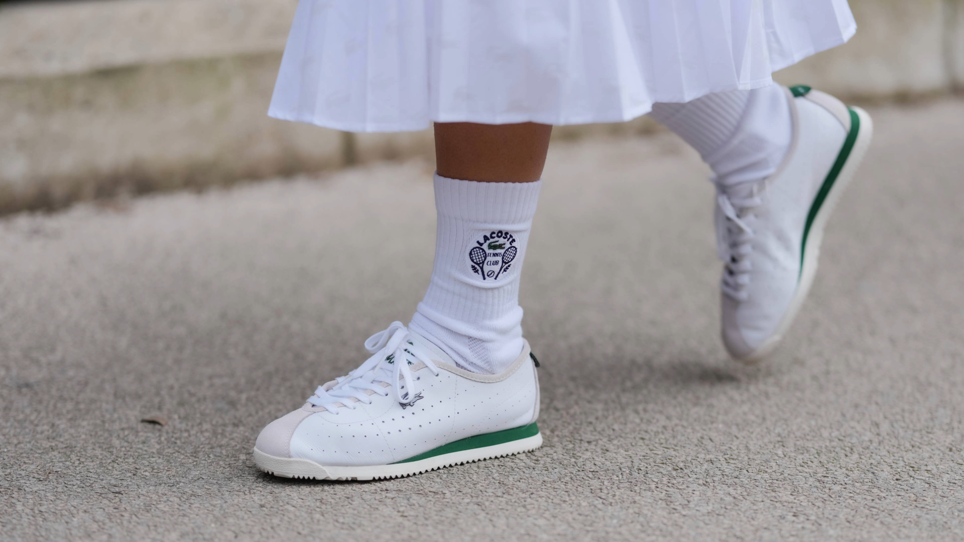 PARIS, FRANCE - MARCH 09: A guest wears white socks, white sneaker shoes, outside Lacoste, during the Paris Fashion week Women's Fall/Winter 2025-2026 on March 9, 2025 in Paris, France. (Photo by Edward Berthelot/Getty Images)