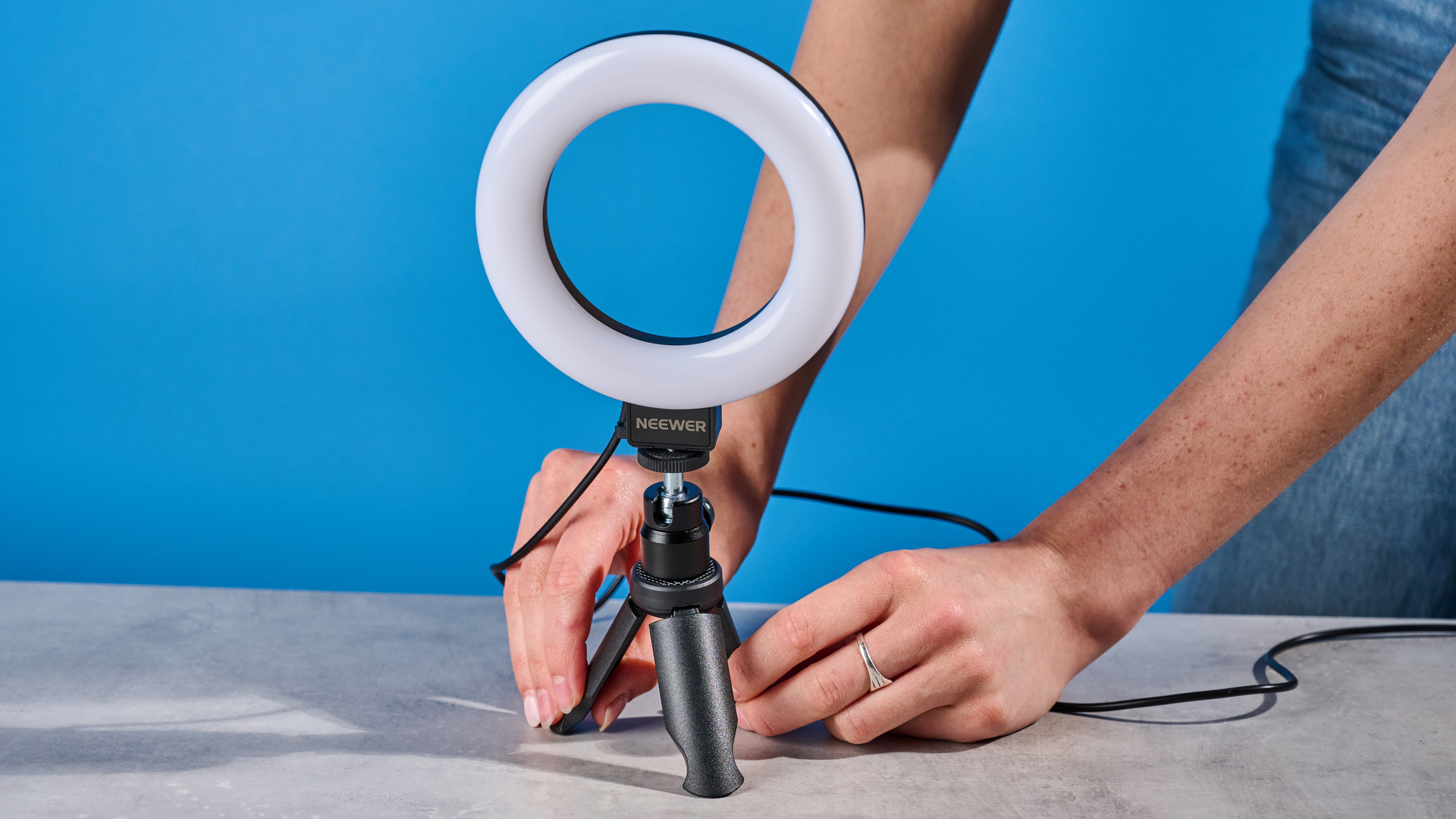 The Neewer Basics BR60 5" Ring Light photographed in front of a blue background.