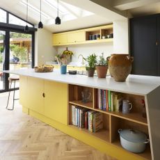 Yellow kitchen with island and open shelf storage