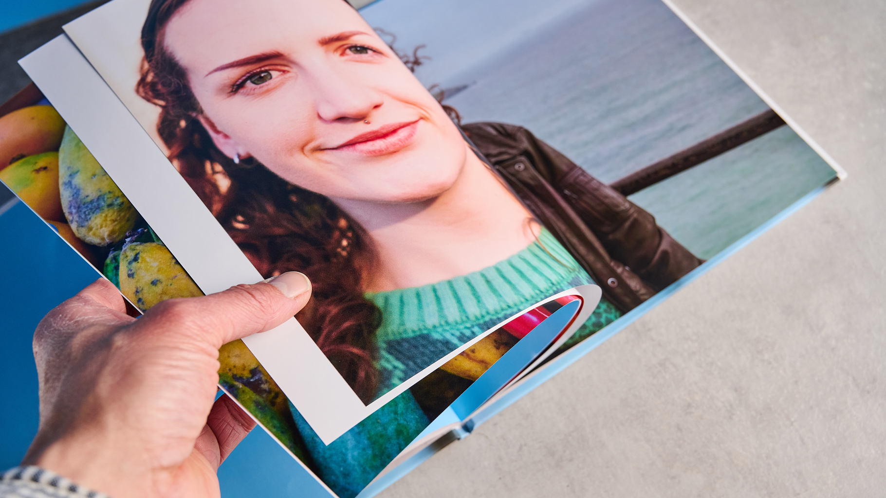Blurb photo book photographed on a table in front of a blue background